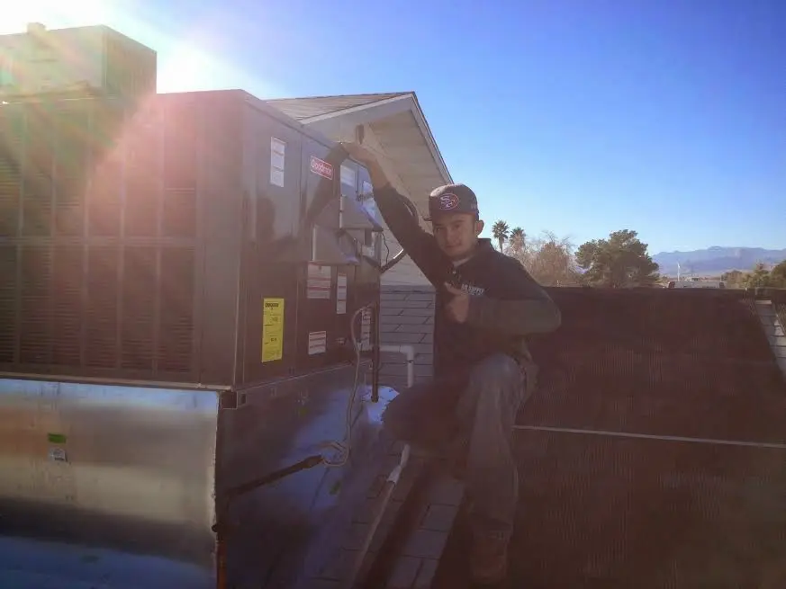 HVAC technician performing Boiler Repair on a rooftop unit in Collinsville